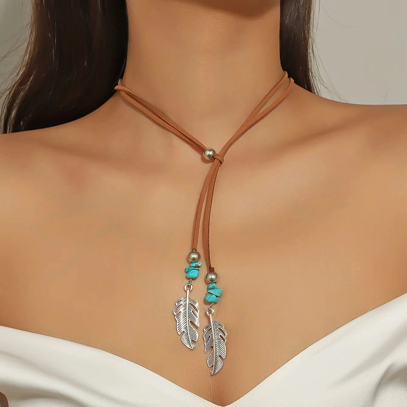 Lariat-halsband i mocka med fjädrar och turkos